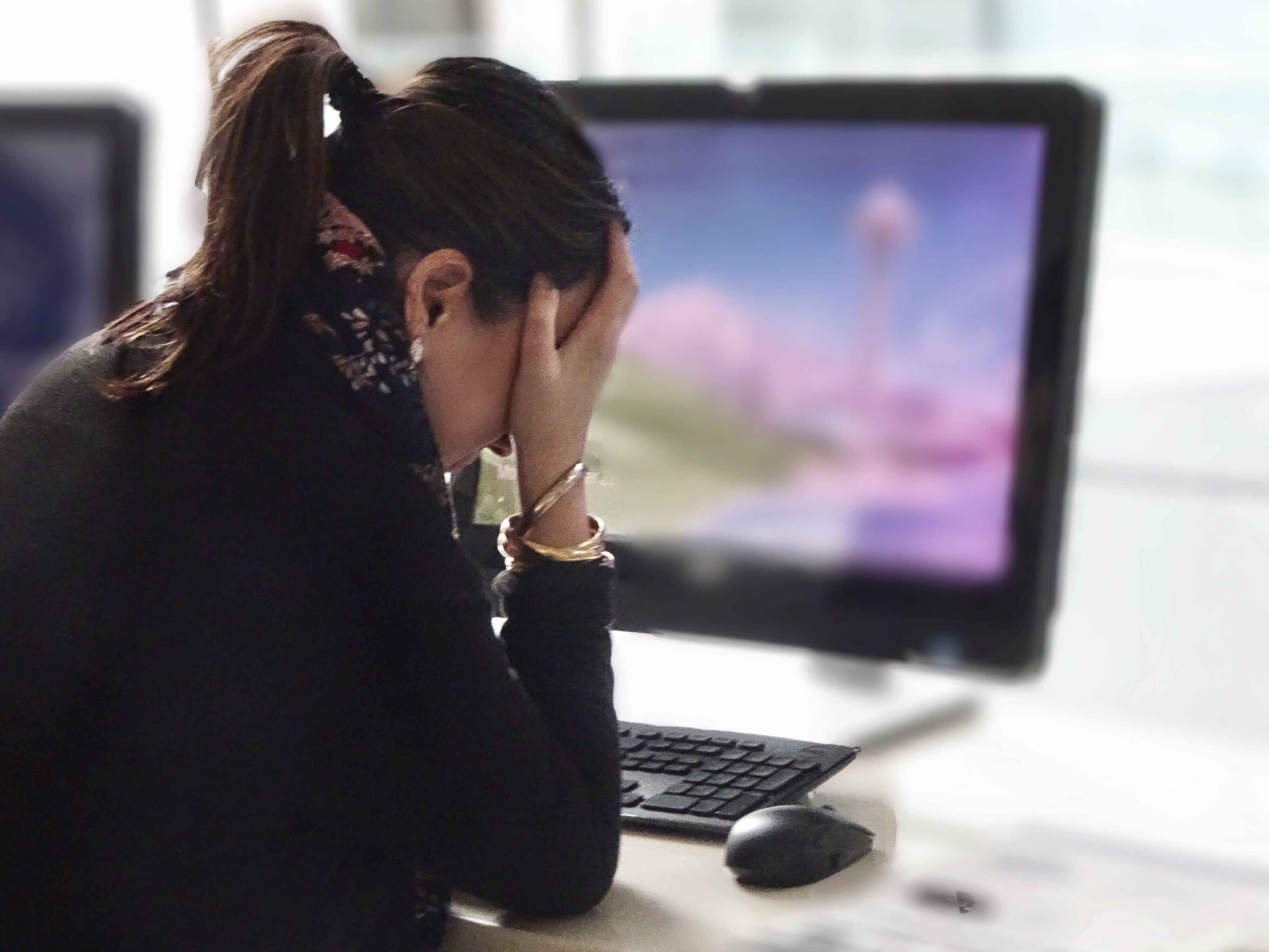 business woman feeling stressed at her desk because of poor mental health